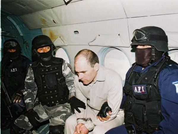 Imagen de archivo de dos policías que escoltan a Osiel Cárdenas (centro), un capo del narcotráfico de México. EFE/PGR