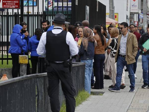 Ciudadanos colombianos solicitantes de visa de EEUU esperan en una fila en la sede de la embajada de los Estados Unidos en Bogotá.