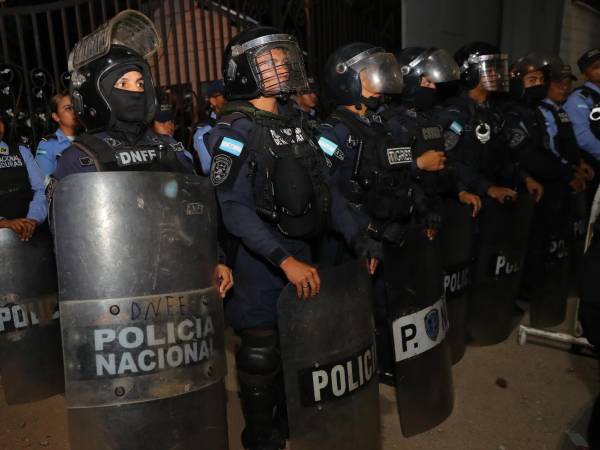 Integrantes de la Policía de Honduras custodian las instalaciones del Consejo Nacional Electoral (CNE) durante una manifestación de simpatizantes del Partido Libertad y Refundación (Libre) por un supuesto fraude electoral en los comicios del 30 de noviembre, este martes, en Tegucigalpa (Honduras.