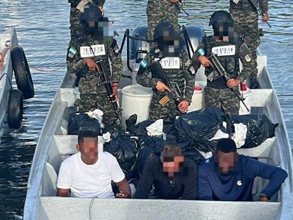 Los tres colombianos detenidos con los 20 fardos de supuesta cocaína.