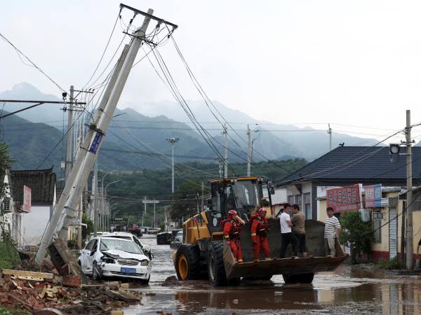 Trabajadores ayudaron a rescatar a personas y a limpiar tras las inundaciones en el distrito de Miyun, en Beijing. (Florence Lo/Reuters)
