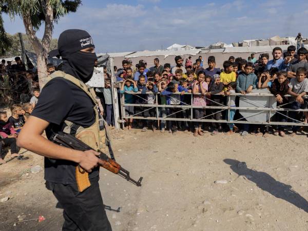 Un hombre armado de Hamas monta guardia durante la entrega de rehenes israelíes en Gaza, el lunes. (Saher Alghorra para The New York Times)