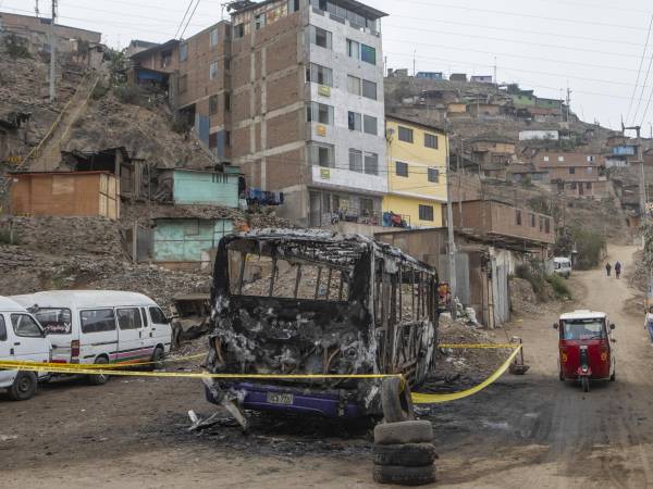 Perú enfrenta una ola delictiva que ha rebasado a las autoridades. Un autobús incendiado en Villa María del Triunfo.