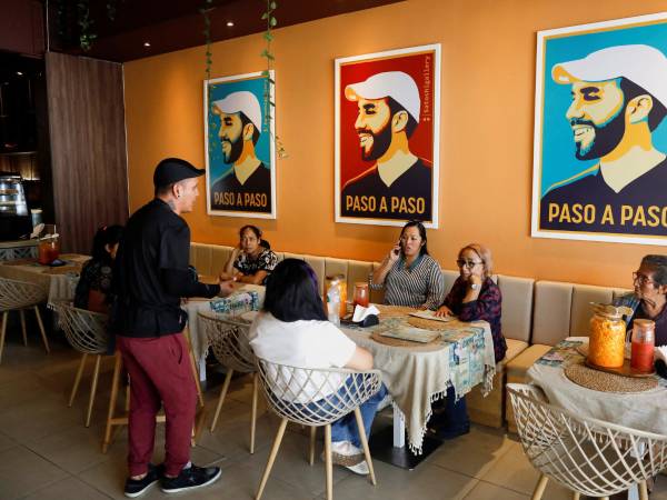 Pósters del Presidente Nayib Bukele en un café en San Salvador. Se abolieron los límites al mandato presidencial. (Jose Cabezas/Reuters)