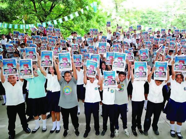 Alumnos del centro educativo muestran felices el fascículo sobre la ansiedad “Una maestra genial”.