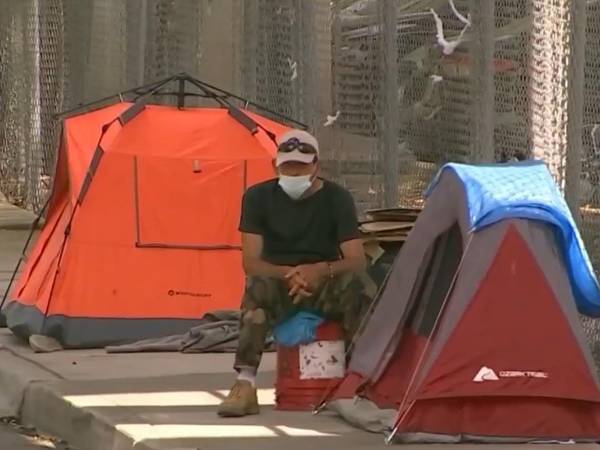 Un hombre descansa cerca de una casa de campaña en Florida.