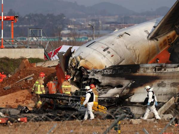 Integrantes del cuerpo del bomberos trabaja en los restos del avión de Jeju Air en el aeropuerto internacional de Muan, al suroeste de Seúl.