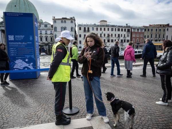 En la estación de tren Santa Lucía, en Venecia, un empleado revisa el registro de visita de un turista.