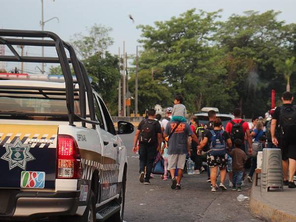 Integrantes de la policía municipal reguardan la seguridad de migrantes que caminan en caravana hacia los Estados Unidos.