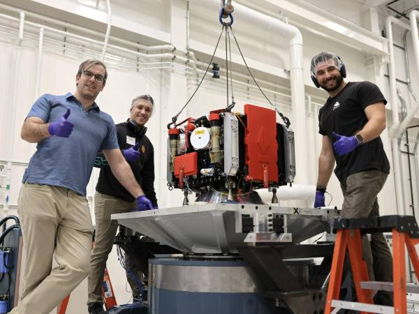 (De izq.) Ashton Meginnis, Wesley Tunelius y Ben Fields, de AstroForge, con Odin durante pruebas de ensamblaje.