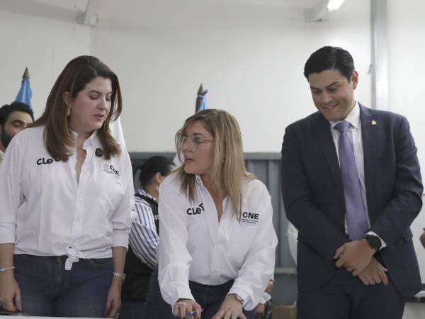 Fotografía de archivo, tomada el pasado 3 de octubre, de los consejeros del Consejo Nacional Electoral (CNE) de Honduras, Cosette López (i), Ana Paola Hall (c) y Marlon Ochoa (d), durante el inicio de la impresión de las papeletas electorales para los comicios de próximo 30 de noviembre.