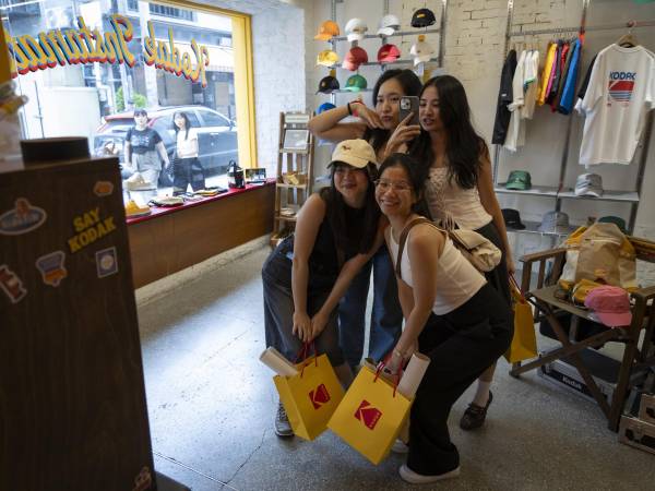 Amigos comprando en Corner Shop, una tienda de ropa Kodak en Seúl. Corea del Sur tiene 123 de estas tiendas.