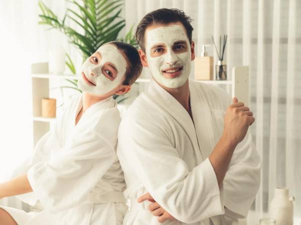 Una pareja tomándose una fotografía después de aplicarse una mascarilla.