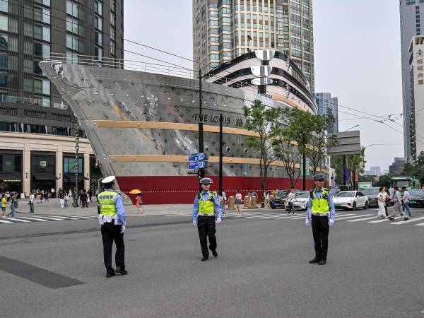 Agentes de policía en Shanghai. Hasta a algunos burócratas menores se les ha ordenado que entreguen sus pasaportes. (Hector Retamal/Agence France-Presse — Getty Images)