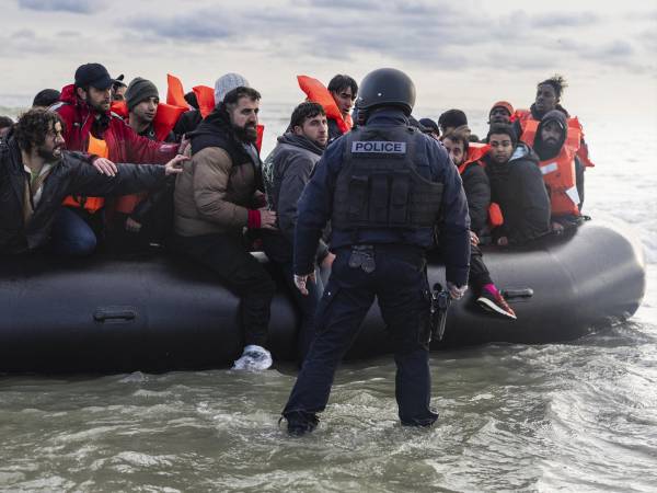 Un policía cerca de Dunkerque, Francia, intenta impedir que migrantes crucen el Canal de la Mancha, en abril.