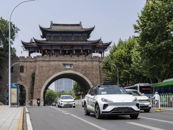 Un taxi Baidu autónomo, sin nadie en los asientos delanteros, recorre las concurridas calles de Wuhan en mayo.