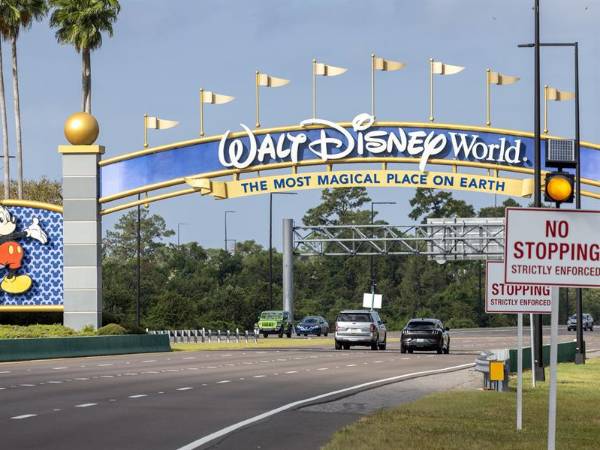 Fotografía de automóviles que pasan bajo una de las puertas de acceso a Walt Disney World en Kissimmee, Florida, Estados Unidos.