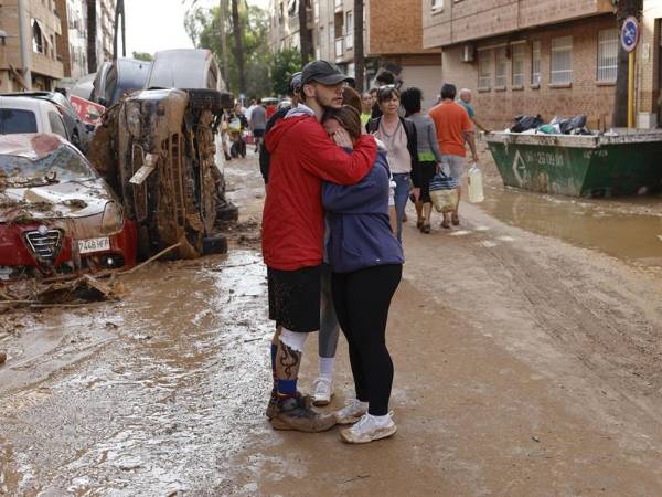 Dos personas se abrazan en la localidad de Paiporta, Valencia, este jueves, en medio de la devastación causada por el temporal.