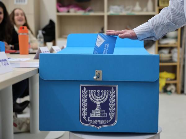 Una persona deposita su voto en una urna en un colegio electoral de Jerusalén este martes. EFE/EPA/ABIR SULTAN
