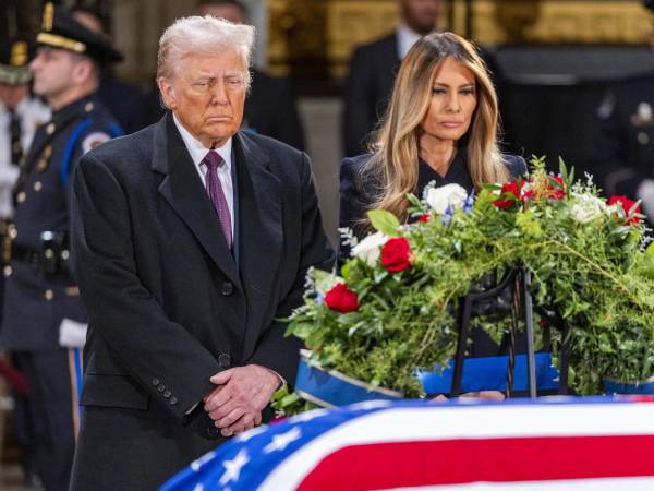El presidente electo de Estados Unidos, Donald J. Trump, y Melania Trump se detienen ante el ataúd envuelto en la bandera del expresidente estadounidense Jimmy Carter.