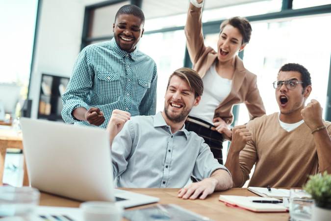Trabajadores en un momento de alegría compartida. Foto de PeopleImages.com-Shutterstock, facilitada por Journalistic.org.
