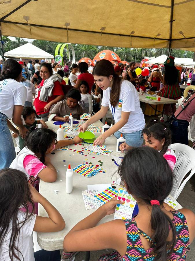 Voluntarios instruyen a niños en los juegos durante la jornada solidaria.