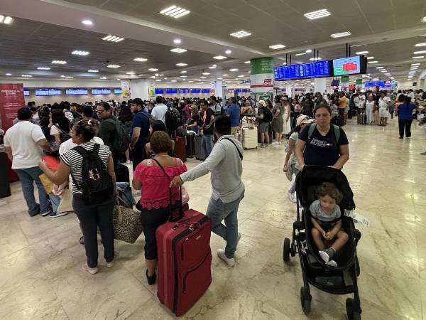Pasajeros esperan para abordar un avión, este miércoles, en el aeropuerto de Cancún (México).