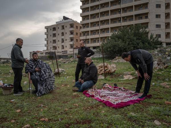 Palestinos desplazados de un campo de refugiados en Yenín, Cisjordania, esperan un corte de pelo en una aldea cercana.