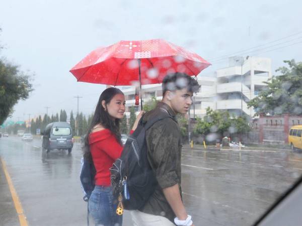 Dos jóvenes caminan durante un día lluvioso en Tegucgalpa.