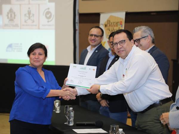 Una de las emprendedores recibe el diploma sobre la formación de habilidades blandas.