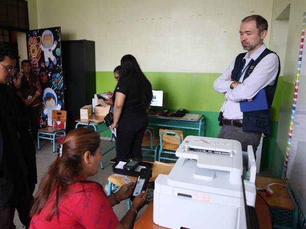 Un observador internacional (a la derecha en la imagen) en un centro de votación durante las elecciones primarias de 2025.