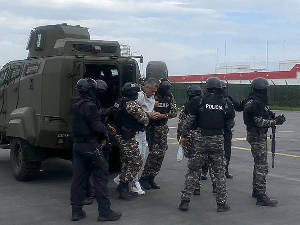 El exvicepresidente ecuatoriano Jorge Glas (C) siendo escoltado por miembros de la policía antes de su traslado a la prisión de máxima seguridad La Roca en Guayaquil, Ecuador.