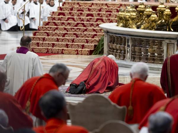 El papa León XIV tendido sobre una alfombra ante el Altar de la Confesión de la basílica de San Pedro del Vaticano durante el rito que conmemora la Pasión de Cristo en el primer Viernes Santo de su pontificado. EFE