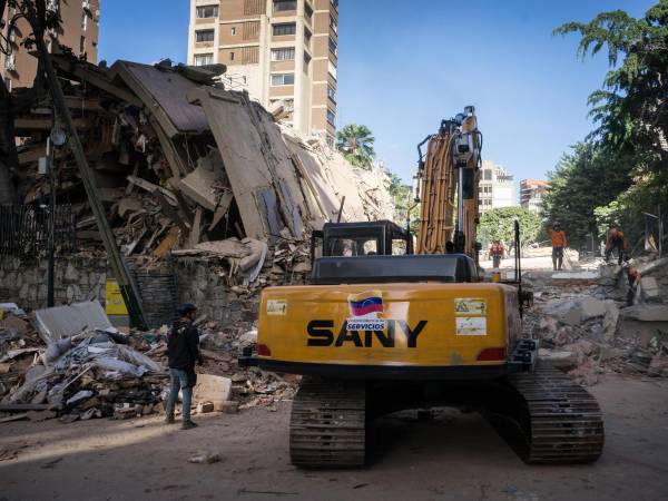 Fotografía que muestra una máquina realizando labores de remoción de escombros y búsqueda de sobrevivientes entre edificios colapsados por los terremotos este jueves, en el municipio de Chacao, en el este de Caracas (Venezuela). EFE/ Boris Vergara