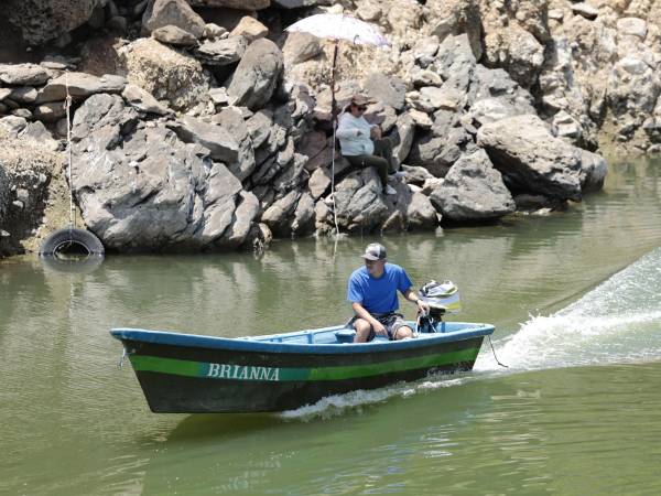 Un hombre a bordo de una lancha recorre un tramo del lago de Güija en Metapán (El Salvador). EFE/Rodrigo Sura