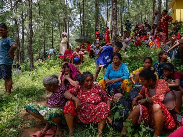 Personas se refugian en un lugar más seguro tras otra alerta de inundación repentina en el distrito de Nuwakot, Nepal, tras la masiva riada del miércoles. EFE/EPA/NARENDRA SHRESTHA