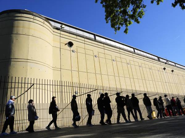 Imagen de archivo de inmigrantes haciendo fila en Barcelona para presentar su documentación ante el proceso de regularización puesto en marcha por el Gobierno español.