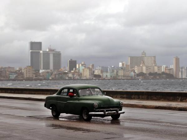 Fotografía de archivo que muestra un vehículo transitando por el malecón en La Habana (Cuba).