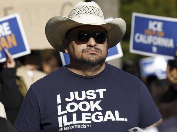 Fotografía de archivo de un hombre con una camiseta en la que se lee Solo parezco ilegal, durante una manifestación.