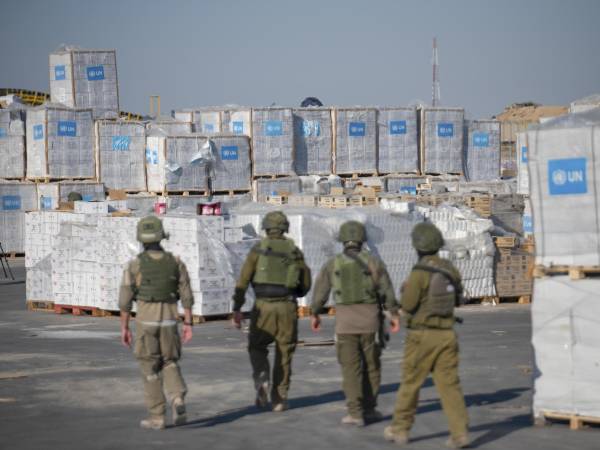 Soldados israelíes ante cargamentos humanitarios de la ONU en el paso fronterizo de Kerem Shalom en una imagen de archivo.