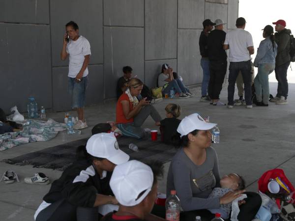 Mujeres con niños se refugian bajo un puente en Ciudad Juárez por la ola de calor.