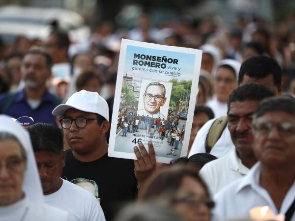 Una persona sostiene un cartel con la imagen de monseñor Óscar Arnulfo Romero durante una peregrinación este sábado, en conmemoración del 46 aniversario de su asesinato en San Salvador (El Salvador). EFE /Rodrigo Sura