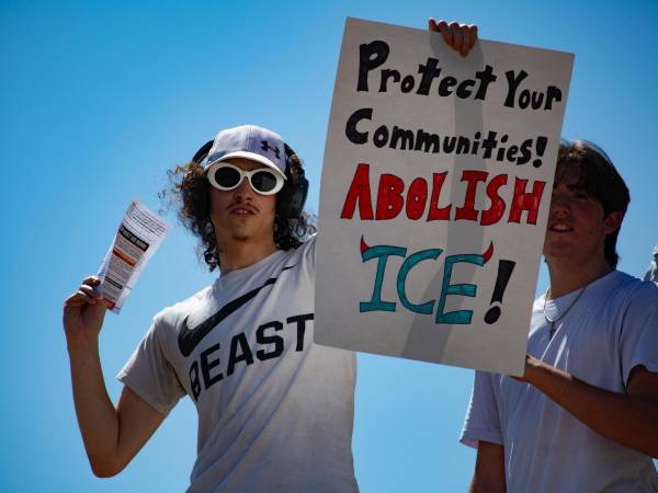 Un hombre sostiene un cartel durante una manifestación en contra del Servicio de Inmigración y Control de Aduanas (ICE) el pasado martes, en Pflugerville (Estados Unidos). EFE/ Carlos Ramírez