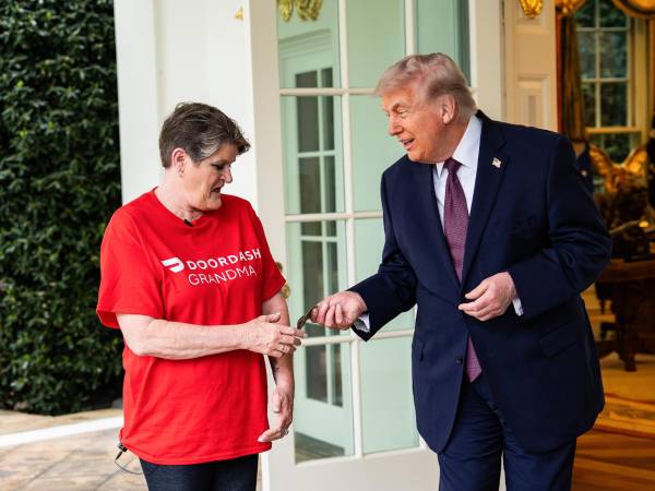 El presidente estadounidense, Donald Trump (derecha), da una propina a Sharon Simmons, empleada de DoorDash, frente al Despacho Oval de la Casa Blanca en Washington, D.C., EE. UU., el 13 de abril de 2026. EFE/SALWAN GEORGES / POOL