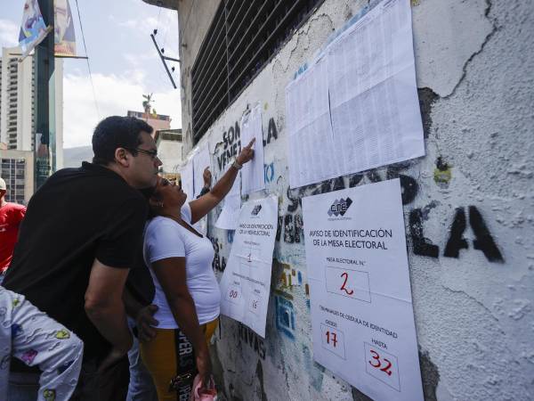 Ciudadanos venezolanos buscan su mesa de votación durante la jornada de elecciones presidenciales de Venezuela este domingo, en Caracas (Venezuela).