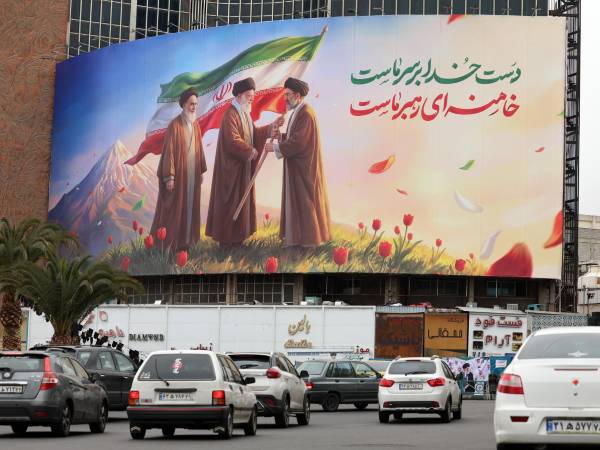 La gente pasa frente a un enorme cartel que muestra al difunto líder supremo iraní Ayatollah Ruhollah Khomeini (L), Ayatollah Ali Khamenei (C) y al nuevo líder supremo iraní Ayatollah Mojtaba Khamenei (R) en la Plaza Valiasr en Teherán, Irán, 10 de marzo de 2026. EFE/EPA/ABEDIN TAHERKENAREH
