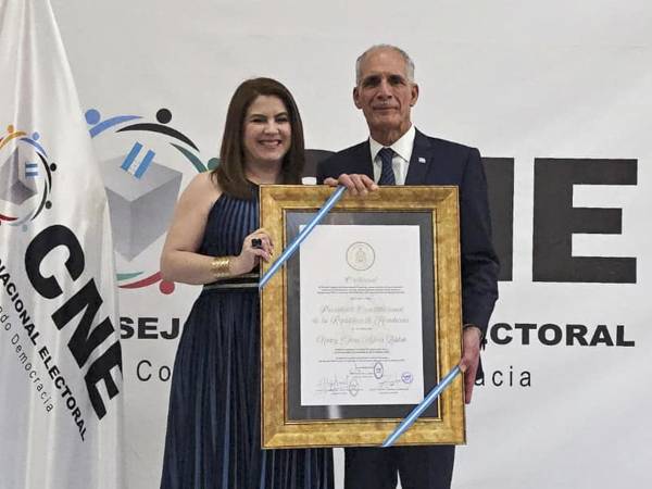 Fotografía cedida por el Concejo Nacional Electoral de Honduras (CNE) donde se observa al electo presidente de Honduras, Nasry Asfura, recibiendo una credencial por parte de la consejera del CNE, Cossette López,.