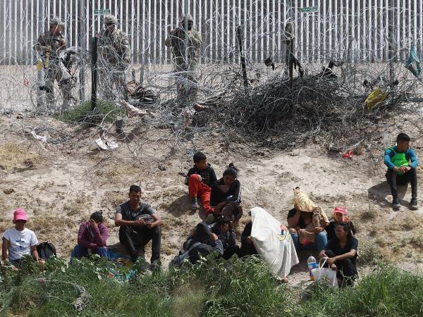 Personal de la Guardia Nacional de Texas vigila a un grupo de migrantes.