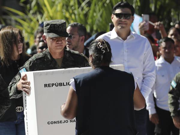 El jefe del Estado Mayor Conjunto de las Fuerzas Armadas de Honduras, el general Roosevelt Hernández (c), sostiene una caja con material electoral en el acto de su distribución para las elecciones generales del 30 de noviembre.