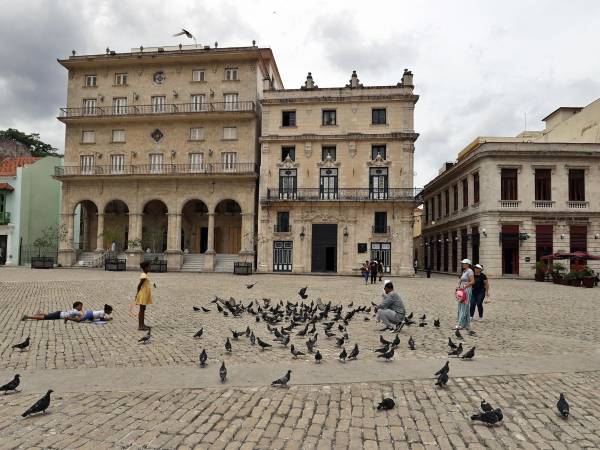 Personas comparten en una plaza el miércoles, en La Habana (Cuba). La grave crisis económica cubana y el miedo a las sanciones de EE.UU. están terminando de desarbolar el sector turístico de la isla, antes motor clave de su crecimiento, con la salida parcial o total de las cuatro grandes hoteleras del país en una semana. EFE/ Ernesto Mastrascusa